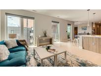 Open-concept living room with large windows, hardwood floors, and a modern kitchen island at 775 Juniper Ne St # 612, Atlanta, GA 30308