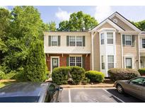 Charming townhome featuring manicured landscaping and assigned parking spaces at 9155 Nesbit Ferry Rd, Alpharetta, GA 30022