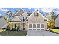 Charming two-story home featuring a brick facade, stylish garage doors, and well-maintained landscaping at 1511 Arica Ave, Lawrenceville, GA 30043