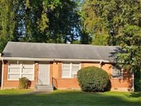Charming single-story brick home featuring a well-maintained lawn and mature trees at 1990 Shamrock Dr, Decatur, GA 30032