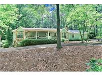 Charming home with stone accents, covered porch, and lush landscaping in a wooded setting at 3320 Bryant Ln, Marietta, GA 30066