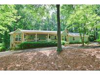 Charming single-story home with a stone-accented facade, nestled among mature trees and lush landscaping at 3320 Bryant Ln, Marietta, GA 30066