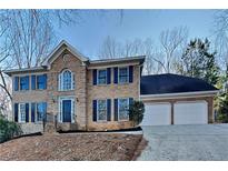Charming two-story brick home featuring dark blue shutters and a two-car garage at 4397 Windsor Oaks Cir, Marietta, GA 30066