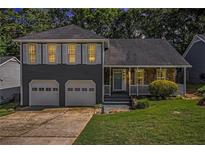 Charming two-story home featuring a stone facade, a covered porch, and a two-car garage at 4865 Fenbrook Dr, Stone Mountain, GA 30088
