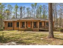 Charming brick home featuring an orange front door and a convenient ramp for easy access at 100 Hall Pl, Fayetteville, GA 30215