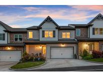 Charming townhouse with brick and stone accents, featuring a well-manicured lawn and welcoming entrance at 8240 Sonata Ln, Cumming, GA 30041