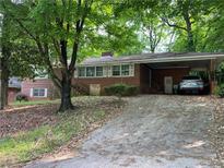 Charming single-story brick home featuring a covered carport and mature trees in a quiet neighborhood at 185 W Lake Nw Dr, Atlanta, GA 30314