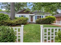Charming home featuring a well-manicured lawn and a classic white picket fence at 220 Sisson Ne Ave, Atlanta, GA 30317