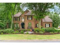A charming two-story brick home with meticulously landscaped front yard and a beautiful fountain at 230 Leaf Court, Alpharetta, GA 30005