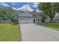Charming two-story home with a well-manicured lawn and a spacious two-car garage and long driveway at 516 Broad Head Pt, Suwanee, GA 30024