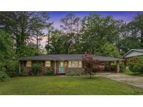 Charming brick ranch-style home with a well-manicured lawn and lush greenery at 890 Oriole Se Ln, Marietta, GA 30067