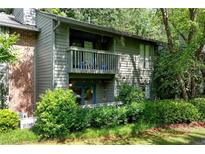 Two-story condo with brick accents and a covered balcony overlooking lush landscaping at 1205 Mcclelen Way, Decatur, GA 30033
