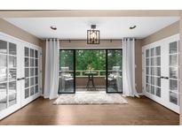 Bright sunroom featuring hardwood floors, neutral paint, and a cozy balcony area with nature views at 25305 Plantation Ne Dr, Atlanta, GA 30324