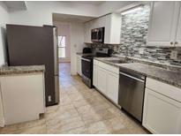 Updated kitchen with stainless steel appliances and decorative tile backsplash at 2565 Terrace Trl, Decatur, GA 30035