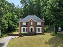 Charming two-story brick home with manicured lawn and mature trees in a peaceful, wooded setting at 3075 Milford Sw, Marietta, GA 30008