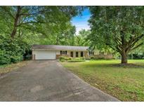 Charming ranch-style home featuring a well-manicured lawn and an attached two-car garage at 450 S Susan Creek Dr, Stone Mountain, GA 30083