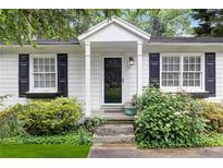 Charming front door with white trim and black shutters surrounded by lush landscaping at 1091 Napier Se St, Atlanta, GA 30316