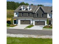 Charming townhomes featuring two-car garages and craftsman-style architectural details at 210 Sharon Ln, Loganville, GA 30052