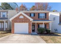 Charming red brick two-story home with a well-manicured front yard and a one car garage at 538 Shadowmoore Dr, Riverdale, GA 30274