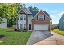 Charming two-story brick home features an attached two-car garage and a well-manicured front lawn at 575 Chapel Walk Ln, Lawrenceville, GA 30045