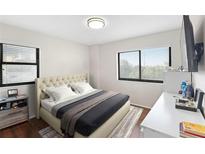Comfortable bedroom featuring a tufted headboard, windows, and a mounted television at 795 Hammond Dr # 505, Atlanta, GA 30328