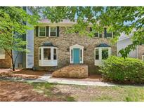 Charming brick two-story home with a bright blue front door and manicured landscaping at 2356 Defoors Ferry Nw Rd, Atlanta, GA 30318