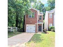 Charming two-story brick home featuring an attached garage and well-maintained front lawn at 2849 Windsor Forrest Ct, Atlanta, GA 30349
