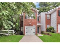 Charming brick home featuring an attached garage and a well-manicured front lawn at 2849 Windsor Forrest Ct, Atlanta, GA 30349