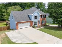 Charming brick and siding home with a spacious driveway and a well-manicured lawn at 2920 Waverly Place Dr, Dacula, GA 30019