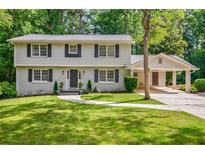 Charming two-story home with a well-manicured lawn, gray shutters, and a convenient attached carport at 4493 Orleans Dr, Dunwoody, GA 30338