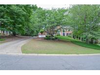 Traditional two-story brick home with mature trees and landscaping at 6450 Oak Valley Dr, Cumming, GA 30040