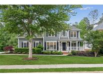 Charming gray two-story home with a well-manicured lawn and a covered front porch at 2572 Hillgrove Dr, Dacula, GA 30019