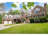 Charming stone home with a well-manicured lawn, two-car garage, and inviting entryway at 355 Clark Creek Pass, Acworth, GA 30102