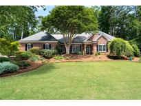Beautiful brick home with lush landscaping and a well-manicured lawn at 4390 Wicklow Ct, Suwanee, GA 30024