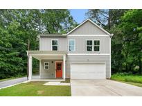 Charming gray two-story home with a well-manicured lawn and bright orange front door at 132 2Nd Nw St, Atlanta, GA 30318