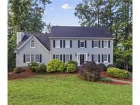 Charming two-story home with a well-manicured lawn and mature landscaping at 4468 Windsor Oaks Dr, Marietta, GA 30066