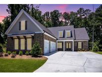 Beautifully landscaped single-Gathering home with a brick facade, two-car garage, and inviting double door entry at 1150 Sweet Mia Ln, Powder Springs, GA 30127