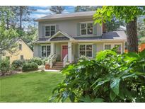 Charming two-story home with well-manicured lawn, pink front door, and beautiful landscaping at 47 Roseclair Se Dr, Atlanta, GA 30317