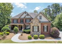 Charming two-story brick home with manicured landscaping and a welcoming front porch at 5925 Water Mark Dr, Cumming, GA 30040
