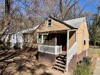 Charming tan home with a covered front porch and lattice foundation, nestled among trees at 1292 Lorenzo Sw Dr, Atlanta, GA 30310