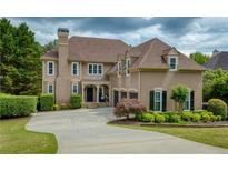 Stately traditional home with manicured lawn, three-car garage, and inviting covered entry at 280 Selkirk Ln, Johns Creek, GA 30097