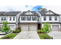Charming townhome featuring stone accents, attached garages, manicured landscaping and a welcoming curb appeal at 6125 Langdon Way, Cumming, GA 30028