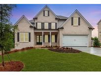 Charming brick home features a manicured lawn, black window shutters, and attached garage at 1077 Sweet Mia Ln, Powder Springs, GA 30127