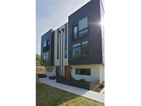 Modern townhome featuring a dark gray and cream color scheme with a small decorative balcony and manicured landscaping at 1153 Reynolds Square Ln # 16, Atlanta, GA 30307