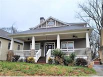 Charming home with a large covered front porch, white railings and stone pillar bases at 2132 Memorial Se Dr, Atlanta, GA 30317