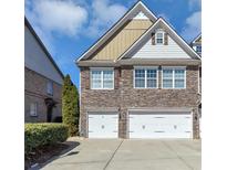 Charming townhome featuring stone accents, a symmetrical facade, and attached two-car garages at 805 Pleasant Hill Nw Rd # 343, Lilburn, GA 30047