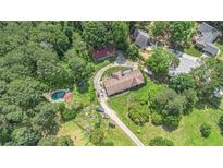 Expansive aerial view showcasing the home, mature trees, a pool, and circular driveway at 2452 Camp Mitchell Rd, Grayson, GA 30017