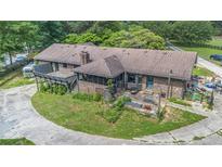 Backyard of brick home with a rustic deck, screened porch, patio, and a circular drive at 2452 Camp Mitchell Rd, Grayson, GA 30017