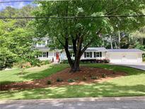 Charming home with a manicured lawn, mature trees, and a bright red front door at 2917 Townley Cir, Atlanta, GA 30340