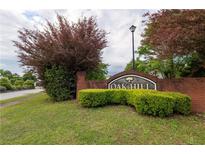Landscaped Oak Hill community sign with brick base and lush green foliage on a cloudy day at 40 Oak Hill Dr, Covington, GA 30016
